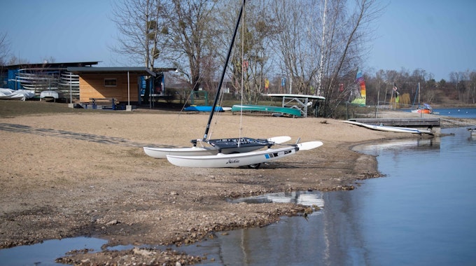 Ein Boot liegt auf dem Trockenen am Rand des Zülpicher Sees. Das Wasser ist zurückgegangen, sodass der Seeboden zu sehen ist.