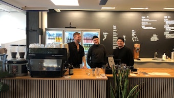 Die drei Betreiber des „Ayni x Schanze“ stehen in schwarzen Pullovern hinter der Theke ihres Cafés.