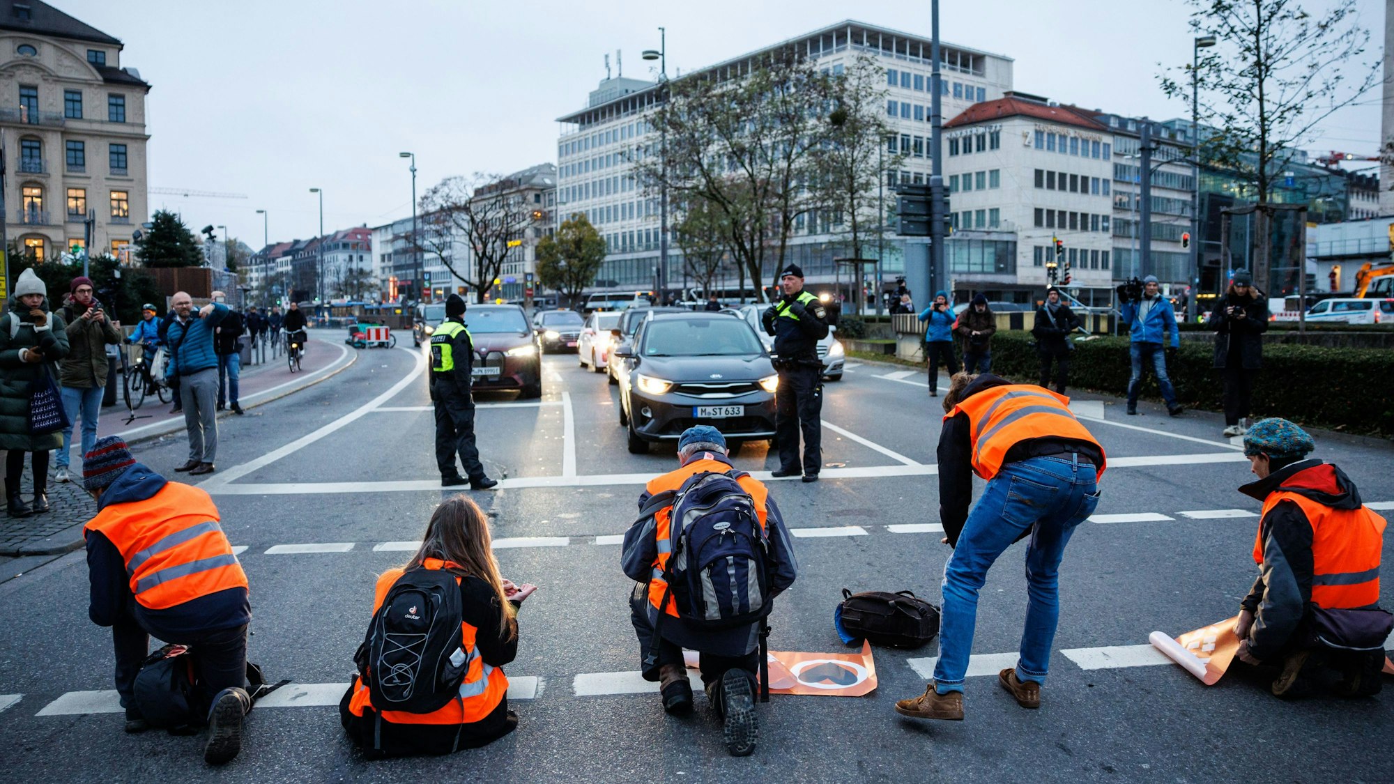 Aktivisten der Klimaschutz-Initiative „Letzte Generation“ sitzen Anfang Dezember in München auf einer Straße.