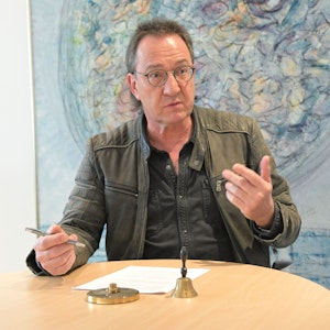 Overaths Erster Beigeordneter Bernd Sassenhof sitzt an einem Tisch und gestikuliert.