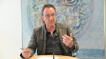 Overaths Erster Beigeordneter Bernd Sassenhof sitzt an einem Tisch und gestikuliert.