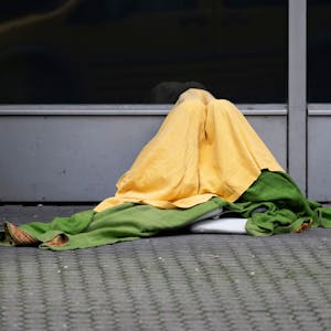 Ein Obdachloser hat sich zum Schutz vor Kälte mehrere Decken um seinen Körper gewickelt.&nbsp;&nbsp;