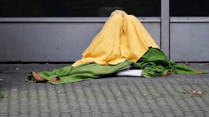 Ein Obdachloser hat sich zum Schutz vor Kälte mehrere Decken um seinen Körper gewickelt.&nbsp;&nbsp;