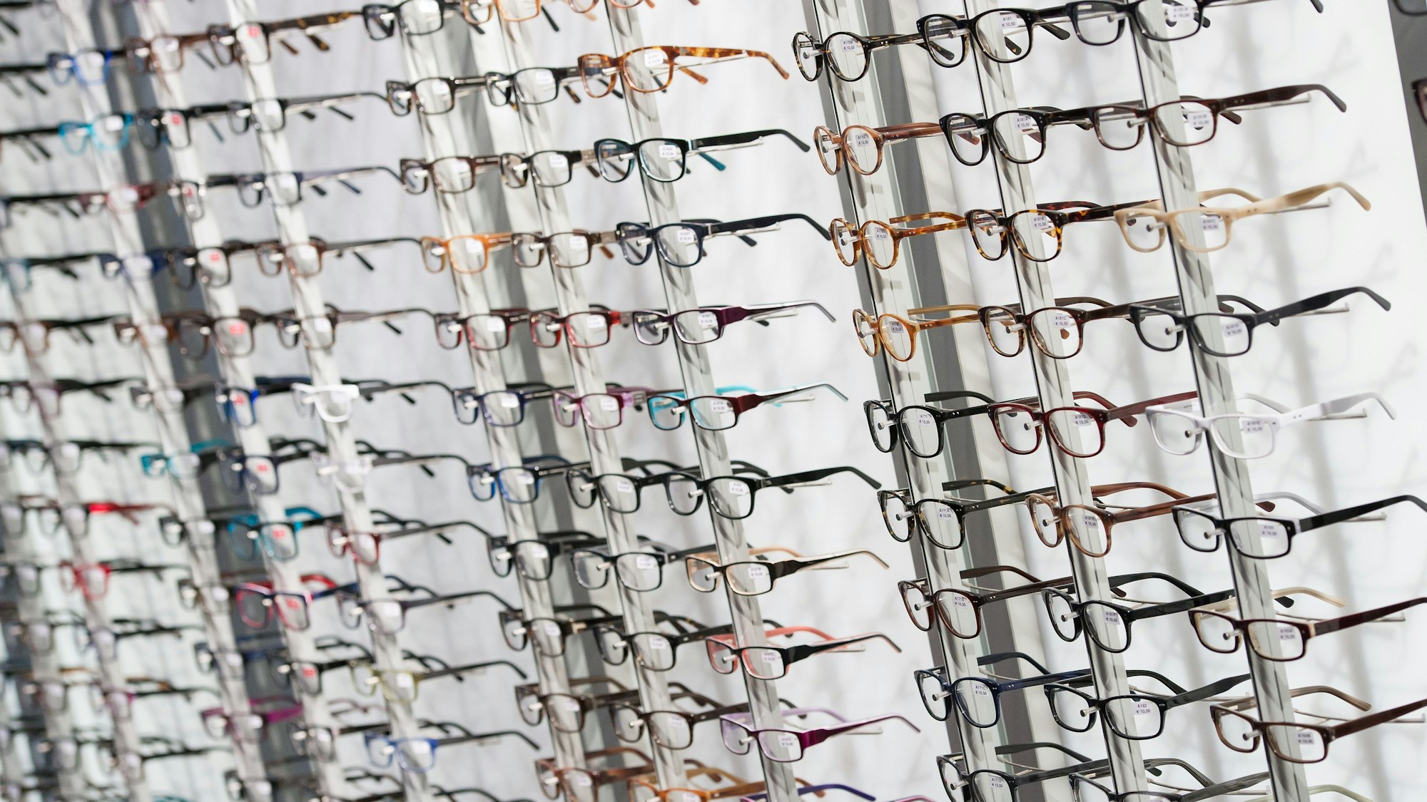 Zahlreiche Brillengestelle hängen an der Wand.