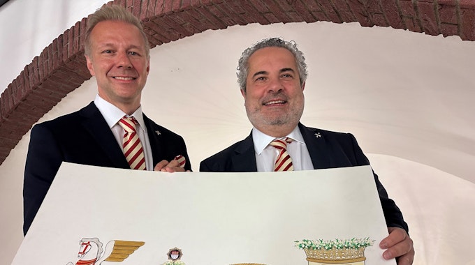 Marcus Gottschalk und Dino Massi zeigen einen Entwurf für den neuen Präsidentenwagen der Prinzen-Garde für den Rosenmontagszug 2023.&nbsp;
