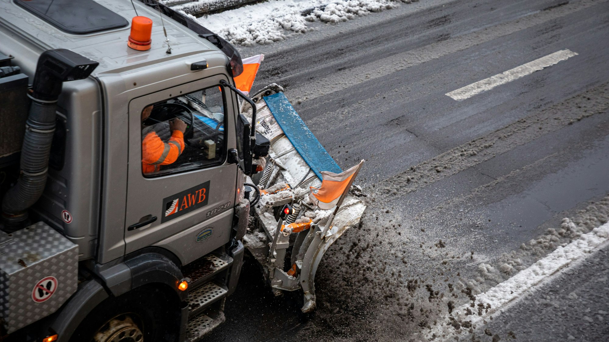 Ein mit einem Schneepflug ausgerüstet Fahrzeug der Abfallwirtschaftsbetriebe Köln (AWB) räumt mit seinem Räumschild Schnee und streut Streusalz auf der Straße „Sülzgürtel“.
