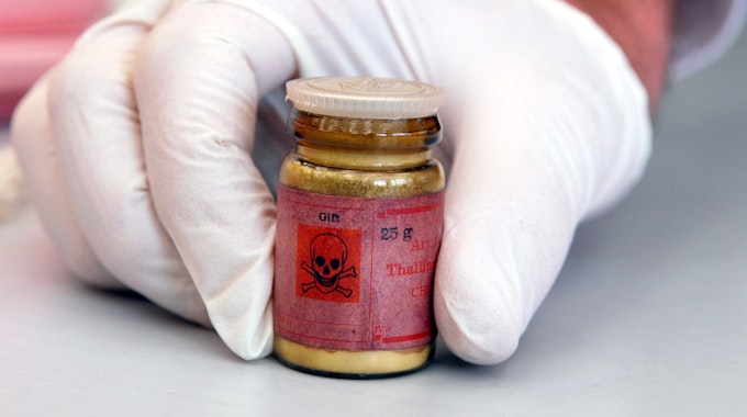 Eine Flasche mit Rattengift aus Thallium, markiert mit einem Totenkopfsymbol auf dem roten Etikett.