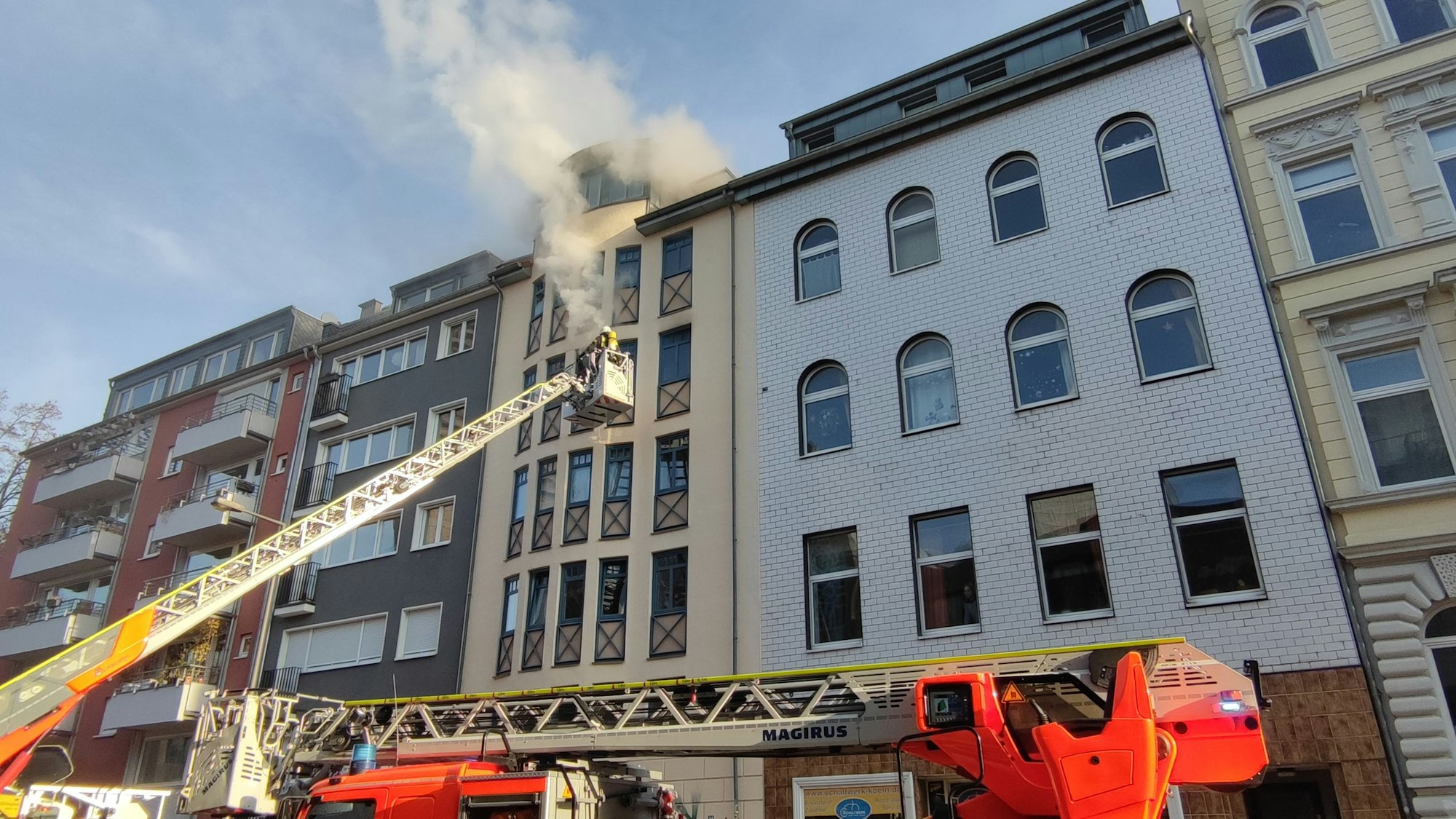 Häuserfront in der Kölner Innenstadt. Aus einer Wohnung kommen dicke Rauchschwaden.