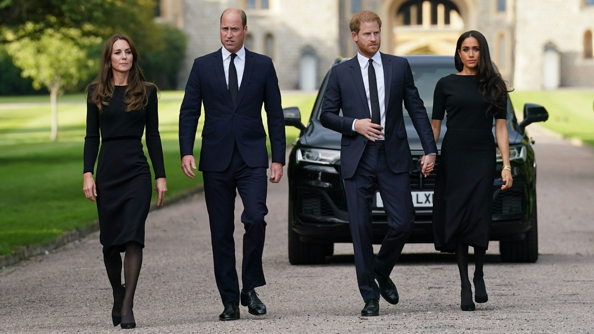 Catherine, Prinzessin von Wales, Prinz William, Prinz von Wales, Prinz Harry, Herzog von Sussex, und Meghan, Herzogin von Sussex auf dem langen Spaziergang auf Schloss Windsor. Sie tragen alle schwarze Kleidung.