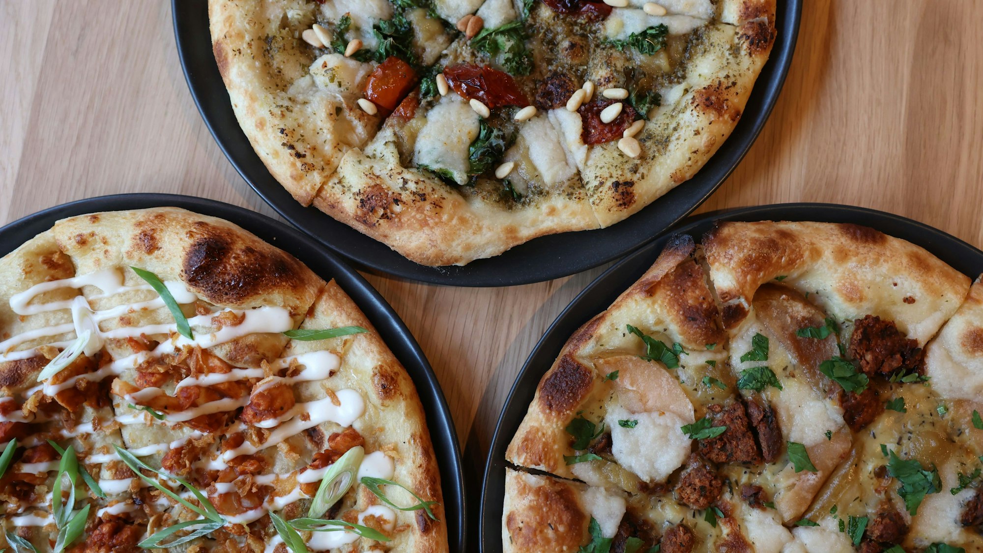 Das Bild zeigt drei Vegane Pizzen von „Virtuous Pie“.