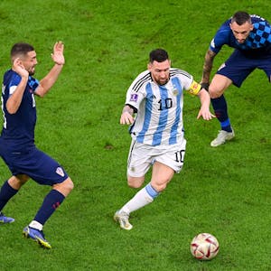 Argentiniens Superstar Lionel Messi dribbelt mit dem Ball durch das Mittelfeld, Kroatiens Mittelfeldstars Brozovic und Kovacic können nur staunend zuschauen.&nbsp;