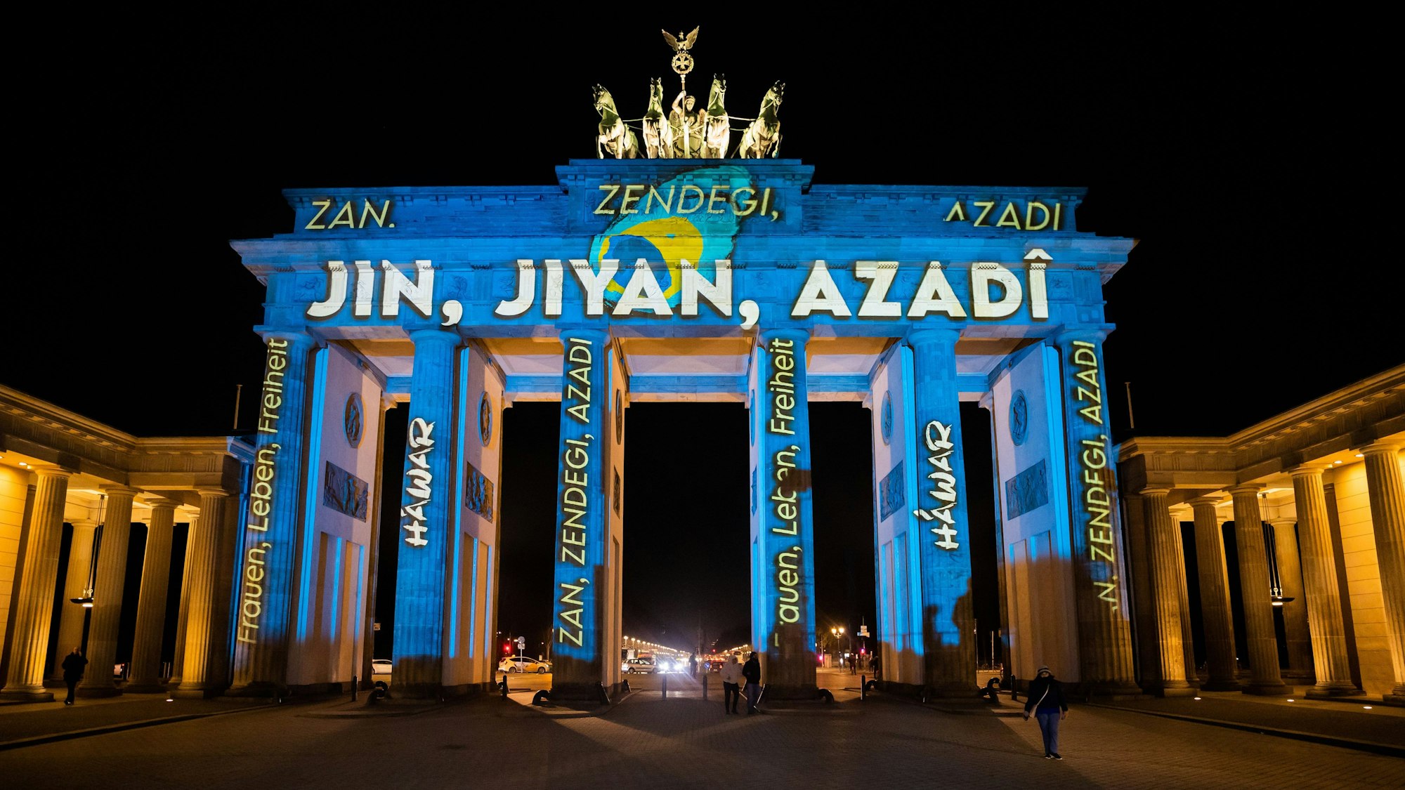 Das Brandenburger Tor wird bei einer Protestaktion für Solidarität mit den Protesten im Iran mit dem kurdischen Schriftzug „Jin, Jiyan, Azadi“ („Frau, Leben, Freiheit“) angestrahlt.