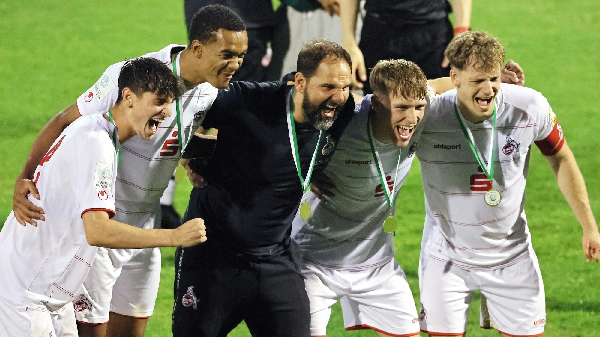 Ein Fußballtrainer freut sich mit seinen Spielern über einen Sieg.
