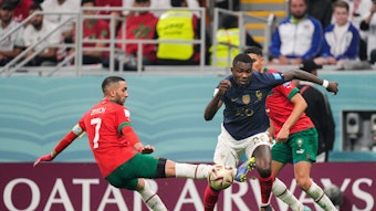 Gladbach-Stürmer Marcus Thuram (M.) ist am Mittwoch (14. Dezember 2022), nach einem Sieg gegen Marokko, mit Titelverteidiger Frankreich ins das WM-Finale in Katar eingezogen. In dieser Szene bekommt es Thuram mit zwei Gegenspielern zu tun, vor ihm befindet sich der Ball.