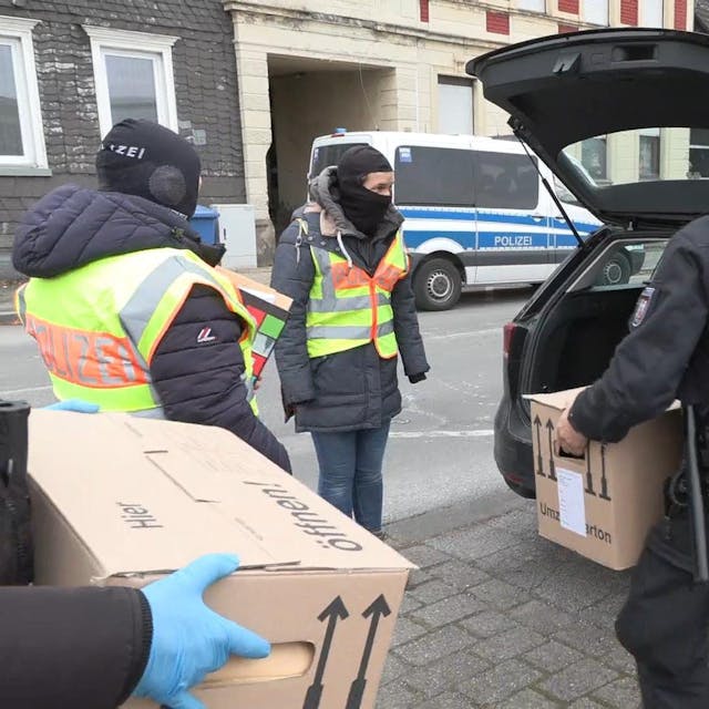 Solingen: Polizisten tragen sichergestellte Beweismittel nach einer groß angelegten Razzia zu ihren Fahrzeugen.