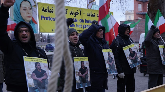 In Berlin protestieren Menschen mit Plakaten gegen die Hinrichtung von Madschid-Resa Rahnavard.