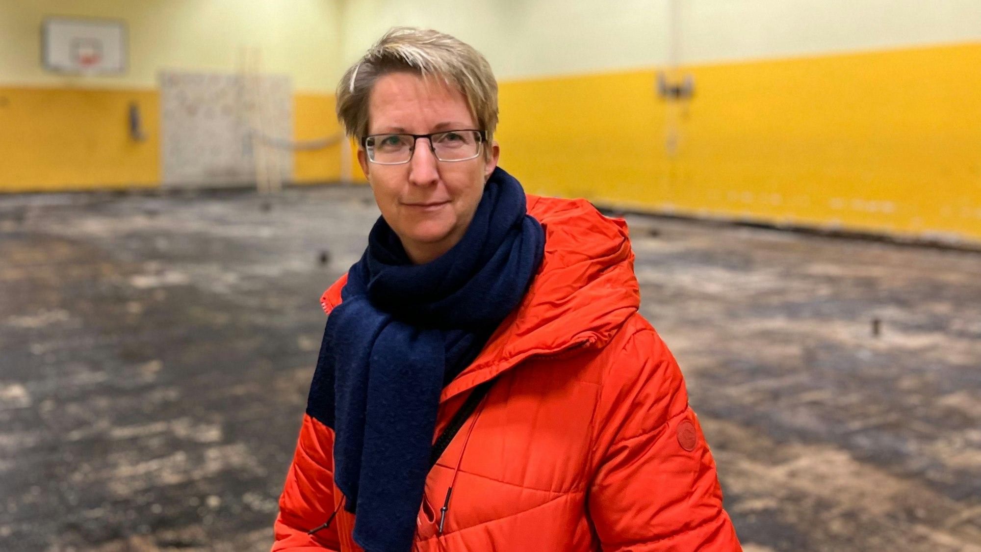Jana Herrmann, Vertreterin der Schulpflegschaft der KGS Kupfergasse in Urbach, steht in der maroden Turnhalle der Schule.