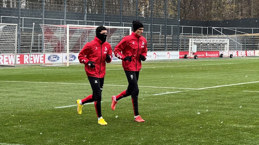 Dejan Ljubicic und Dimitrios Limnios laufen über den Rasen beim Training des 1. FC Köln.