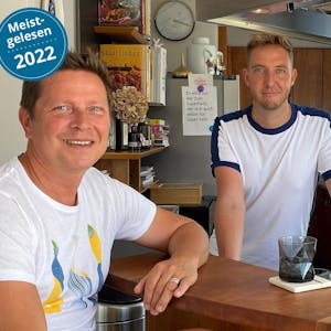 Steffen Müller-Lücke (links) und Thomas Lücke stehen an der Bar in ihrem Penthouse in der Kölner Innenstadt.