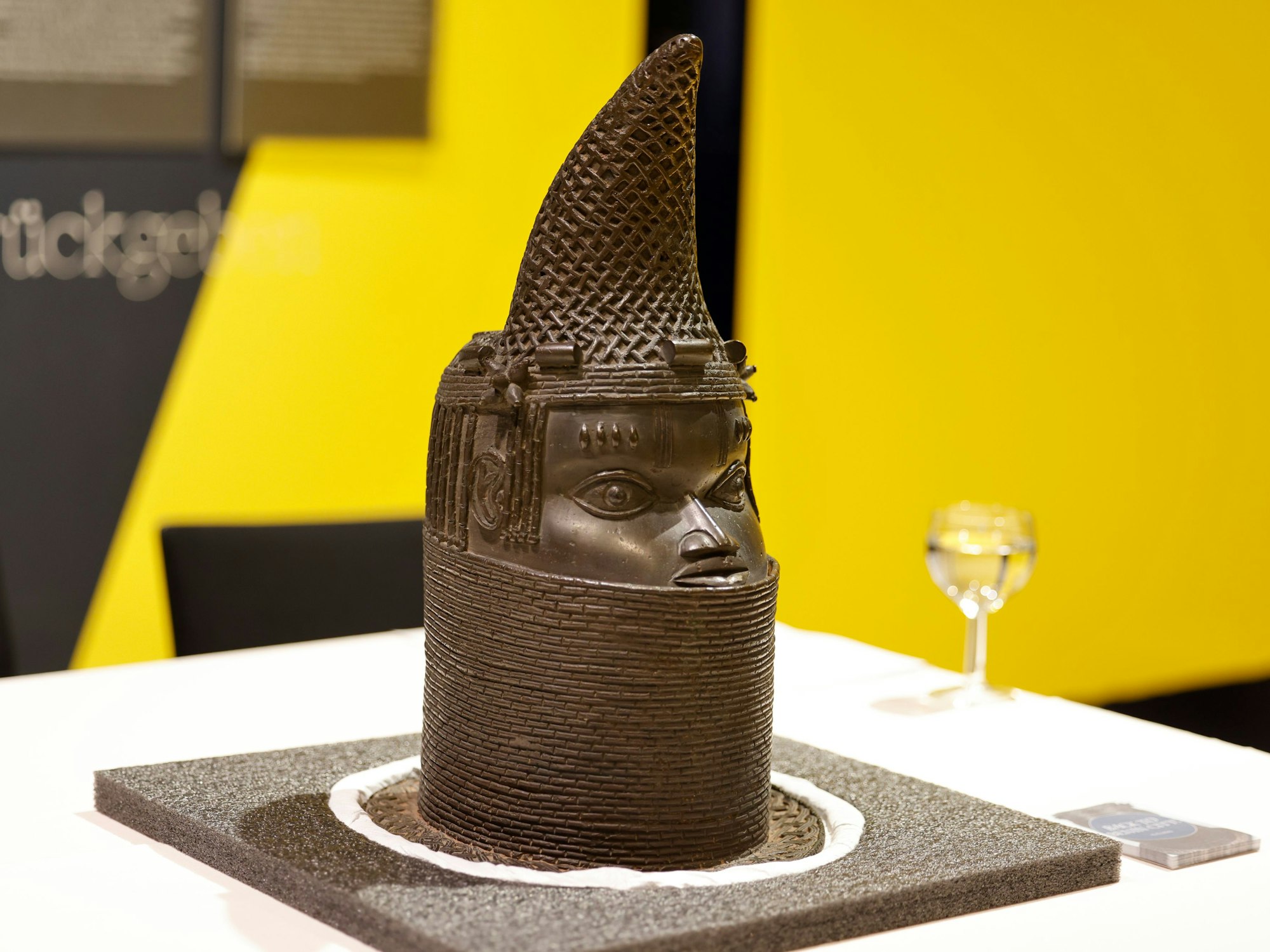 Ein Gedenkkopf aus Kupfer steht vor der Vertragsunterzeichnung zur Rückführung von Benin-Bronzen aus Köln auf dem Tisch.