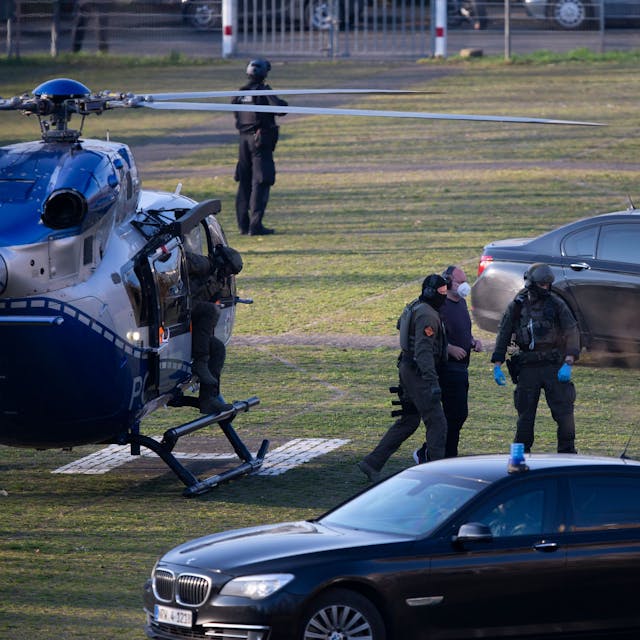 Thomas Drach steigt in Begleitung von Sicherheitskräften aus einem Hubschrauber aus