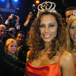 Die Miss Germany 2004 lächelt nach ihrem Sieg in die Kamera. Sie trägt eine Krone.