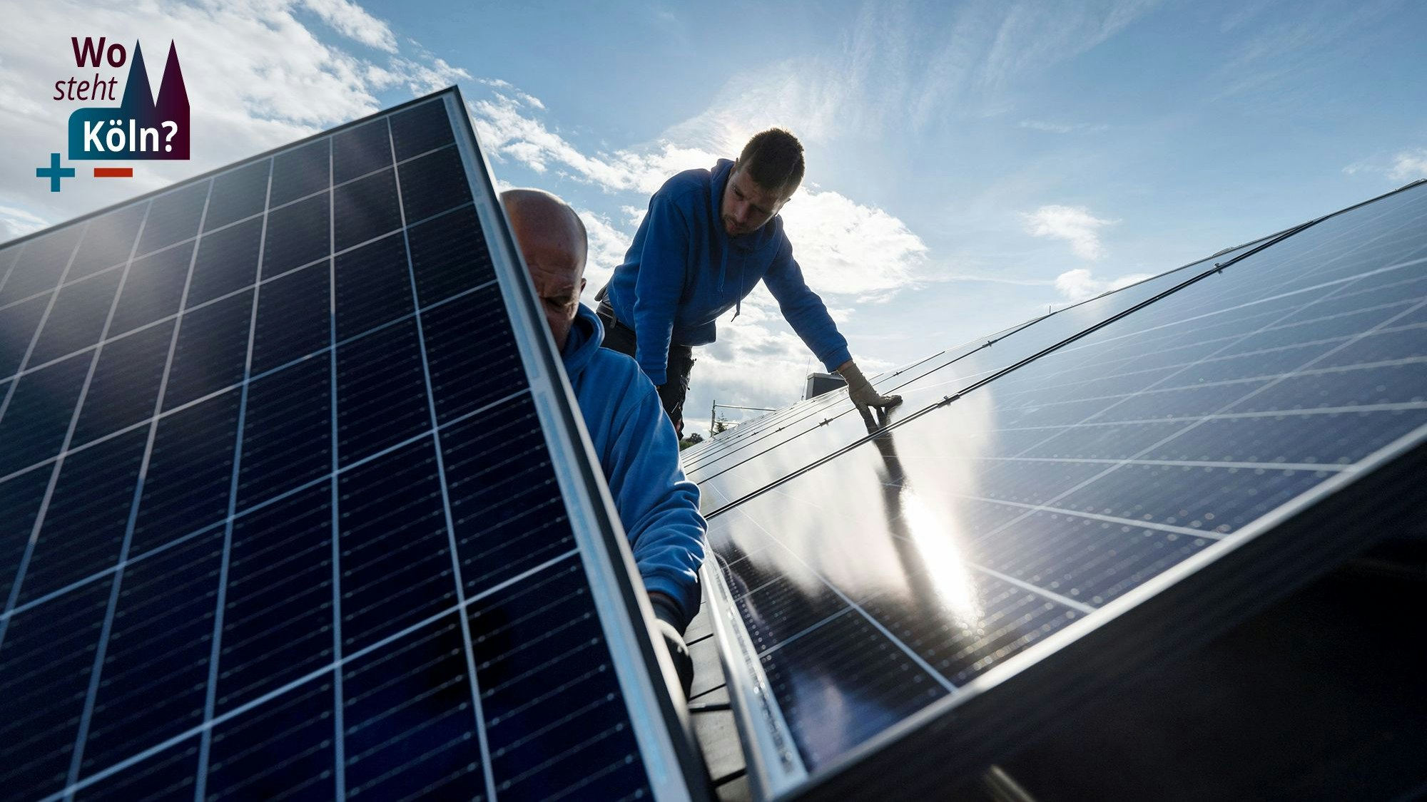 Techniker montieren Photovoltaikmodule auf dem Dach eines Wohnhauses.