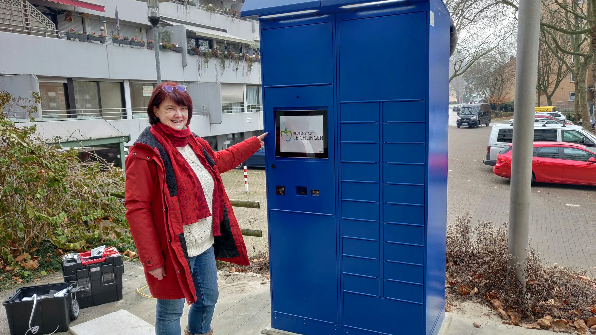 Amtsleiterin Brigitte Gutendorf steht neben dem blauen Ausweis-Automaten vor dem Rathaus.