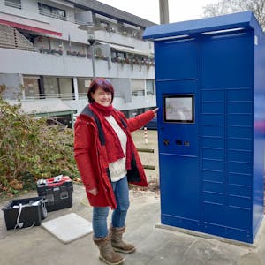 Amtsleiterin Brigitte Gutendorf steht neben dem blauen Ausweis-Automaten vor dem Rathaus.