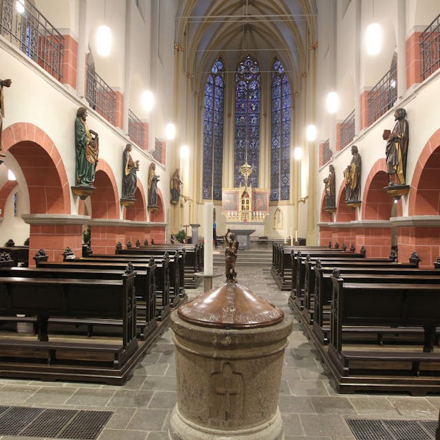 Der Innenraum der Siegburger Kirche St. Servatius mit seinen hölzernen Kirchenbänken ist zu sehen.
