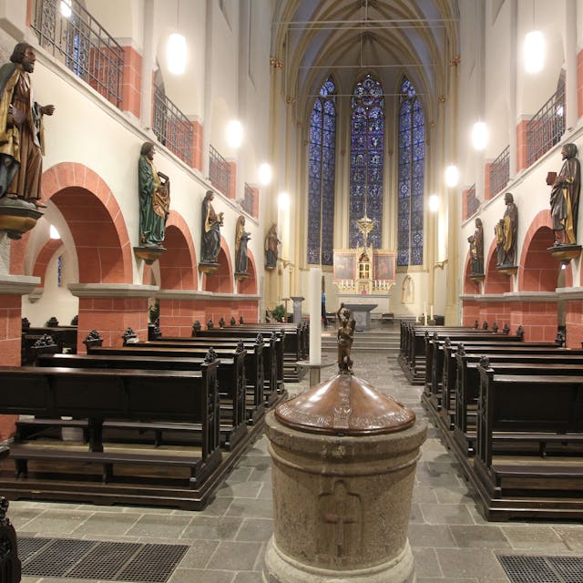 Der Innenraum der Siegburger Kirche St. Servatius mit seinen hölzernen Kirchenbänken ist zu sehen.