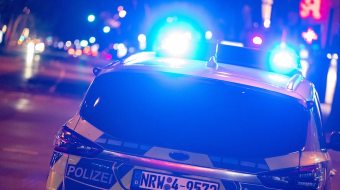 Ein Fahrzeug der Kölner Polizei fährt mit Blaulicht.