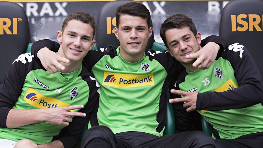 Amin Younes posiert mit Branimir Hrgota und Granit Xhaka für ein Foto auf der Bank von Borussia Mönchengladbach.