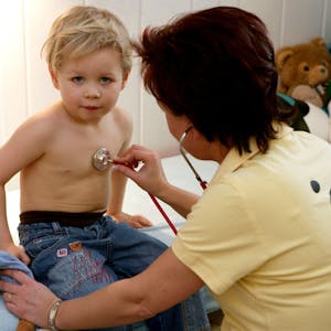 Eine Kinderärztin aus Frankfurt&nbsp; untersucht in ihrer Praxis einen kleinen Jungen mit einem Stethoskop.&nbsp;