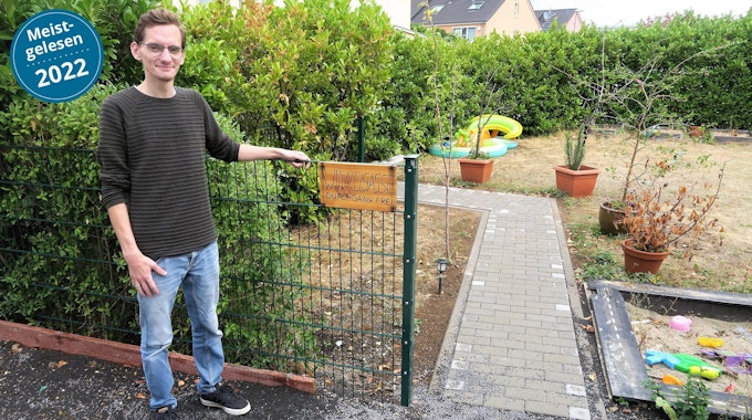 Djordje Atlialp steht vor einem Gartenzaun. Ein Schild daran trägt die Aufschrift „Wikelgasse“.