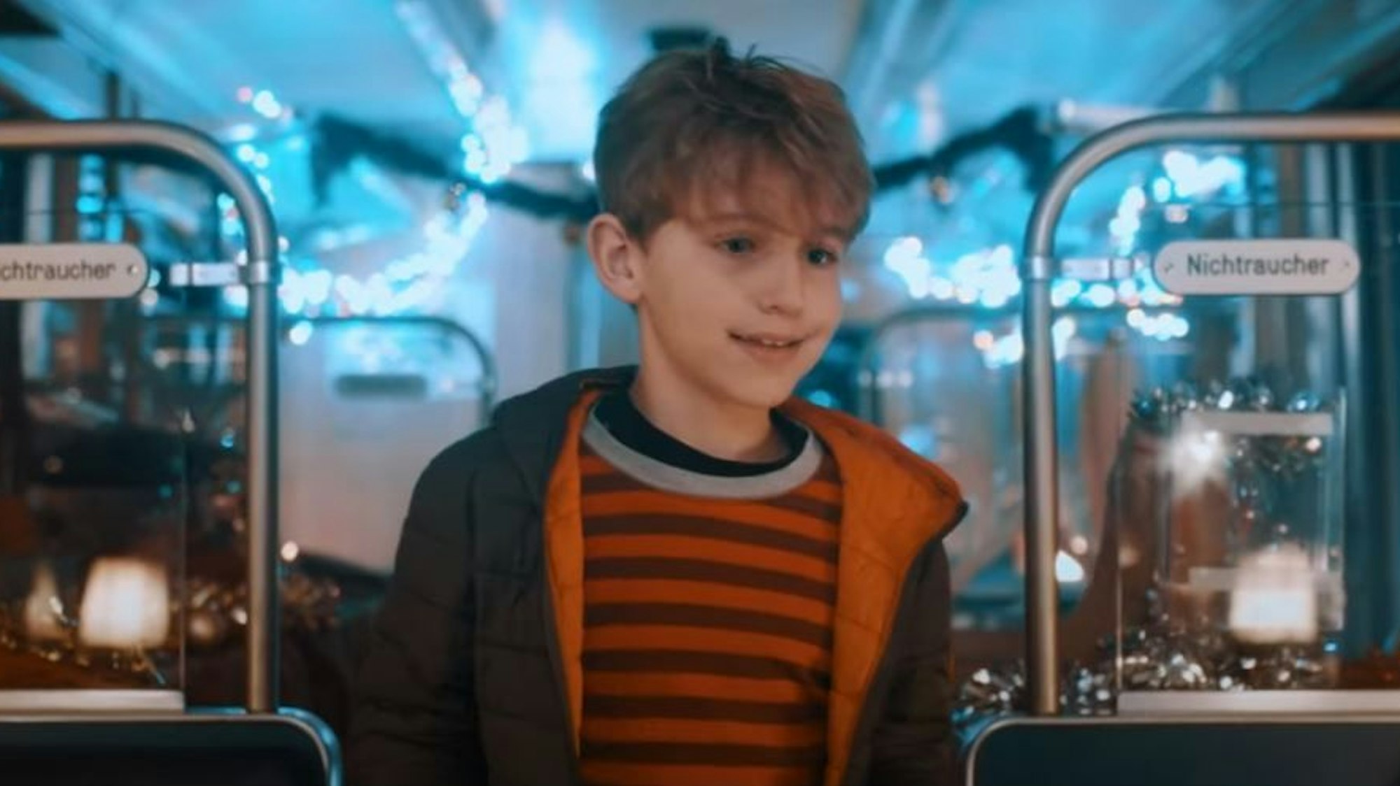 Der kleine Leon geht im Weihnachts-Video der KVB durch einen Zug, der weihnachtlich geschmückt ist.