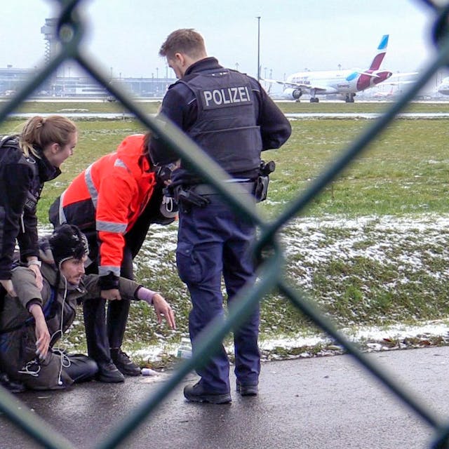 Zwei Beamte der Bundespolizei und ein Sicherheitsmitarbeiter steht mit einem sichergestellten Bolzenschneider an einem Zaun am BER-Flughafen. Aktivisten hatten versucht auf das Rollfeld zu gelangen.