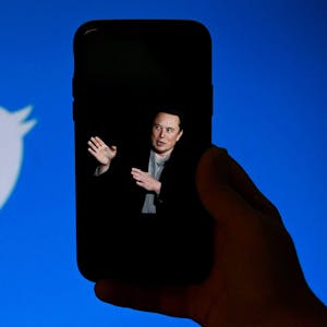 Auf diesem Dateifoto vom 4. Oktober 2022 zeigt ein Telefonbildschirm in Washington, DC, ein Foto von Elon Musk mit dem Twitter-Logo im Hintergrund.