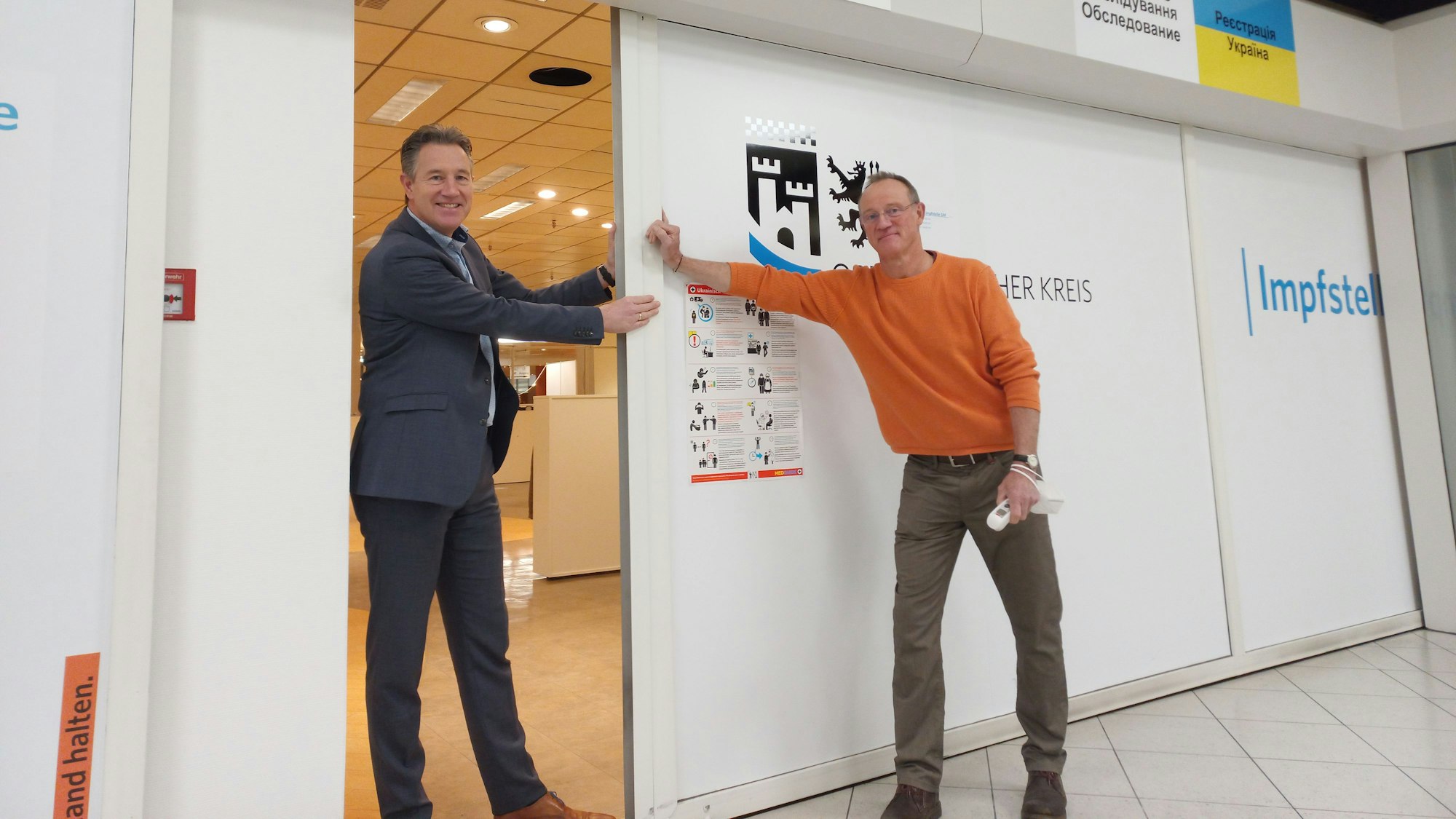 Sozialdezernent Ralf Schmallenbach (l.) und Impfzentrum-Leiter Uwe Alefelder schließen die Tür des Impfzentrums.
