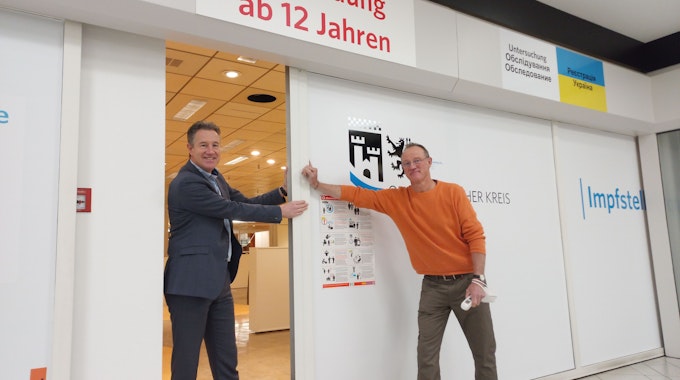 Sozialdezernent Ralf Schmallenbach (l.) und Impfzentrum-Leiter Uwe Alefelder schließen die Tür des Impfzentrums.