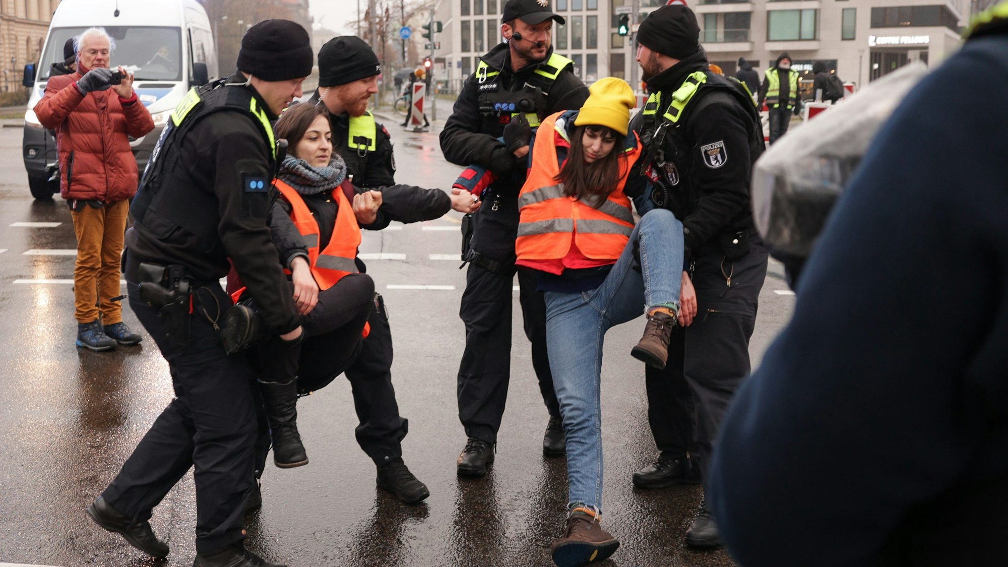 Klimaaktivisten werden von der Invalidenstraße getragen, nachdem sie sich auf dem Asphalt festgeklebt hatten.