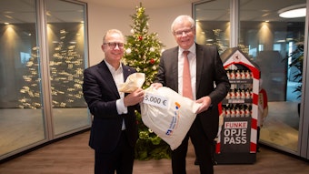 Hilfreich: Jürgen Pütz, Vorstandsvorsitzender der Volksbank Köln Bonn, überreicht Helmut Heinen, Vorsitzender der Altenhilfe, einen symbolisch einen „Sack Geld“.