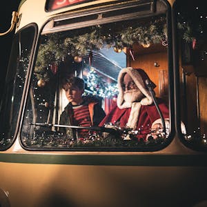 Der Weihnachtsmann und ein Junge sitzen zusammen in der Fahrerkabine einer historischen Stadtbahn der KVB.