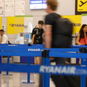 Menschen gehen zum Abfertigungsschalter von Ryanair am Flughafen von Palma de Mallorca.
