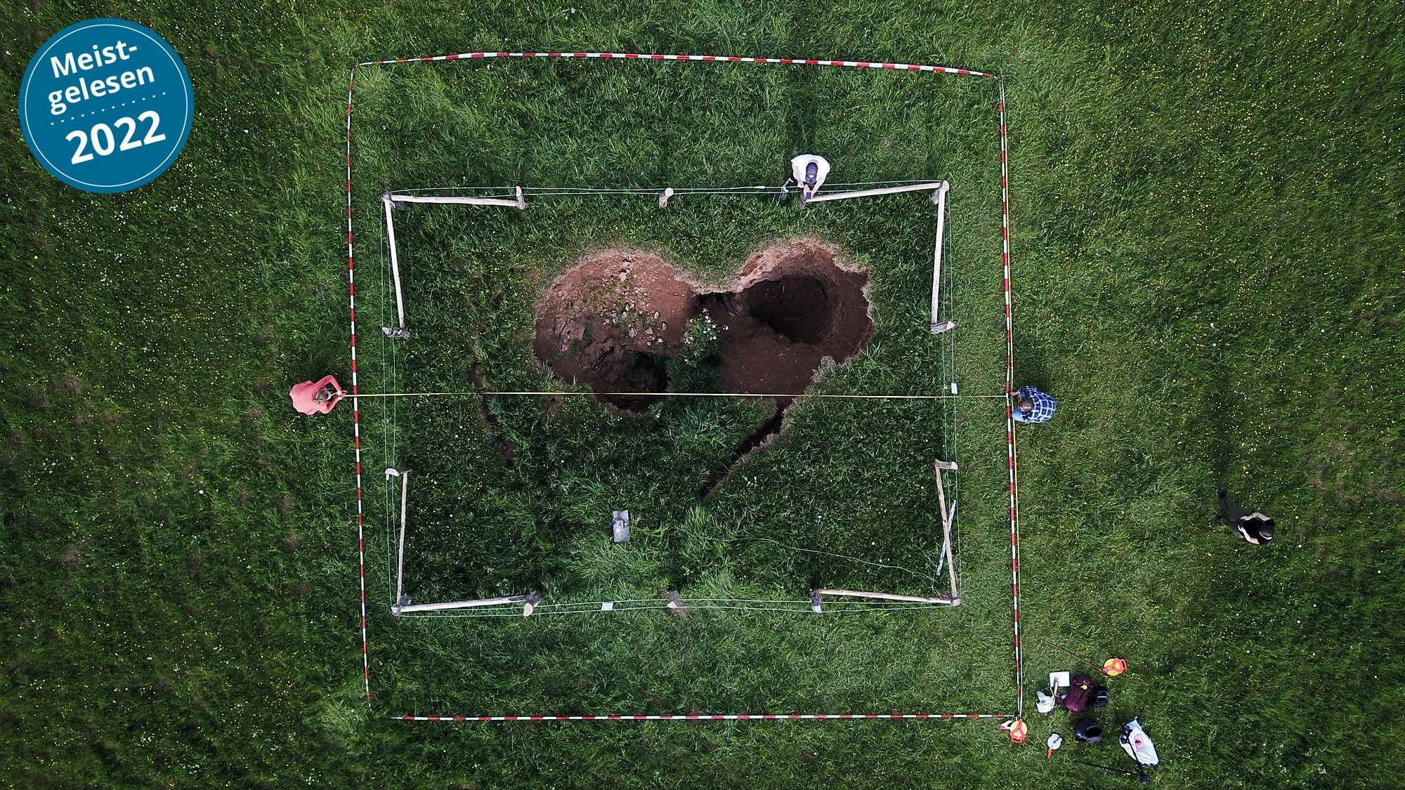 Ein unheimliches Loch mitten auf der Wiese: Drohnenbilder lassen einen herzförmigen Einsturzkrater erkennen.
