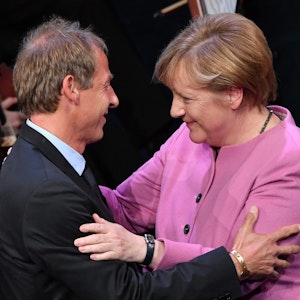 Jürgen Klinsmann und Angela Merkel umarmen sich herzlich.