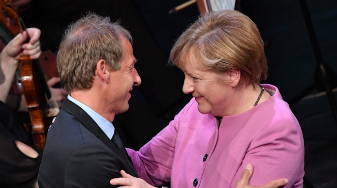 Jürgen Klinsmann und Angela Merkel umarmen sich herzlich.