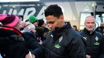 Gladbachs Relegations-Held Igor de Camargo wird von Tausenden Fohlen-Fans am Samstag (17. Dezember 2022) im Borussia-Park empfangen. Im Hintergrund ist Ex-Trainer Holger Fach zu sehen. De Camargo schreibt Autogramme.
