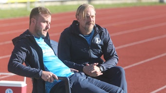 Co-Trainer Daniel Jamann (links) und Chefcoach Thomas Klimmeck sitzen auf dem Trainerstuhl und schauen skeptisch drein.
