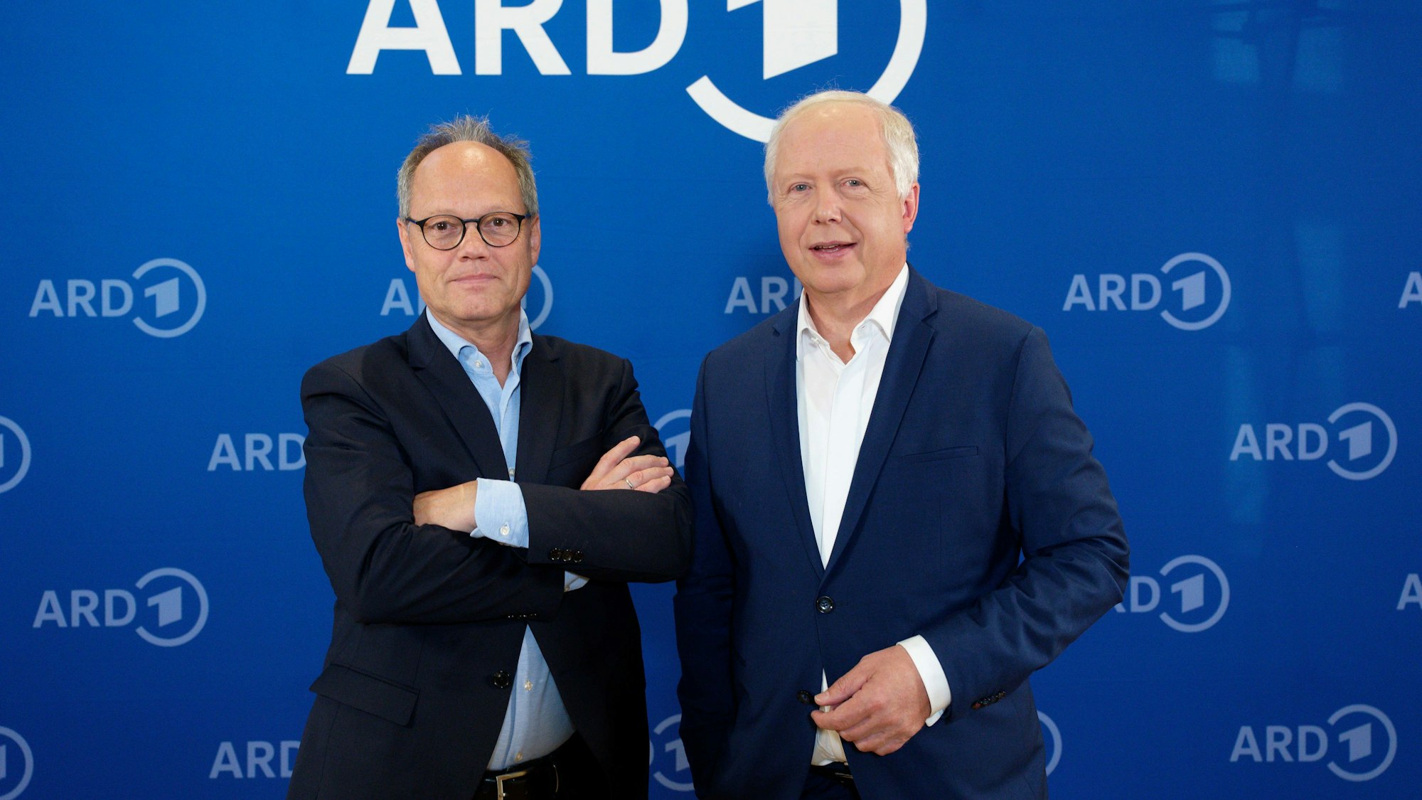 Kai Gniffke, SWR-Intendant und zukünftiger ARD-Vorsitzender, und Tom Buhrow, aktueller ARD-Vorsitzender und WDR-Intendant, stehen nach einem Pressegespräch vor einer Wand mit ARD-Logos.